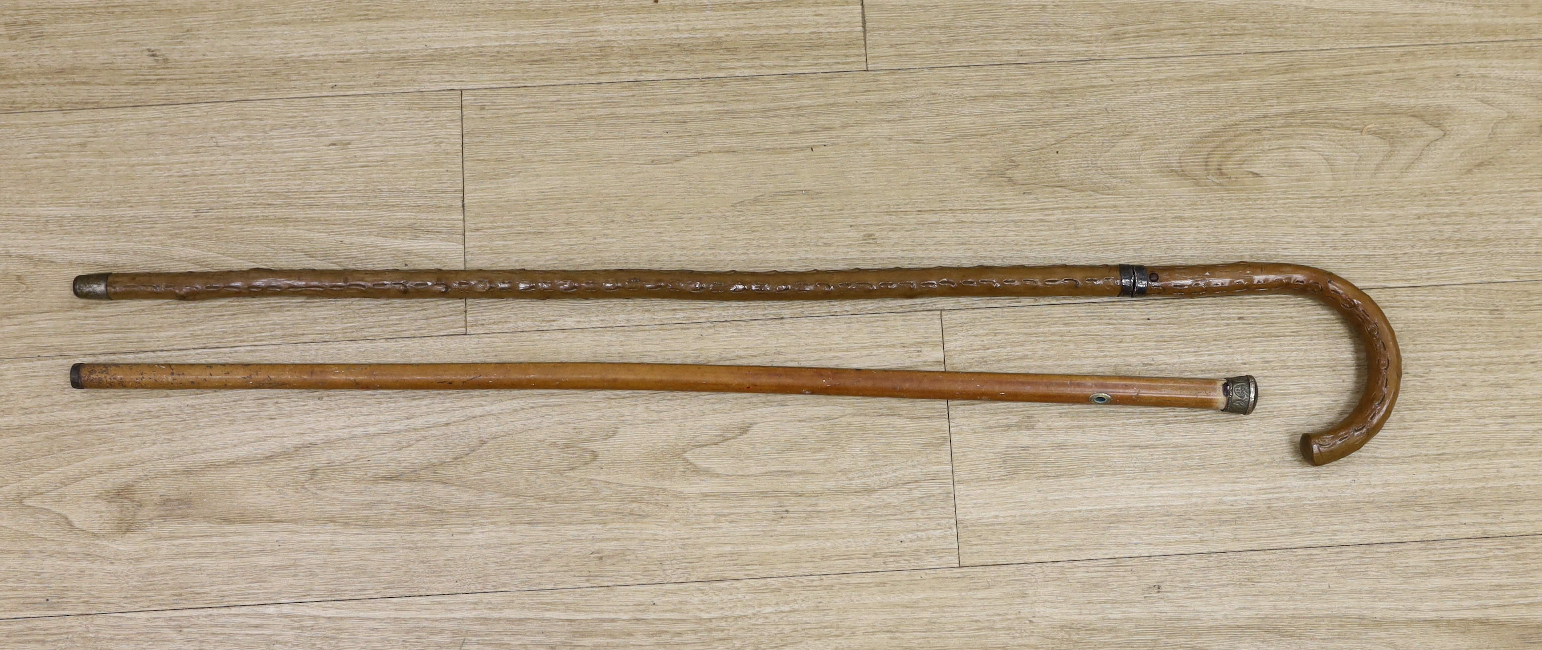 An early 20th century sword stick and a metal topped cane, sword stick 91cm long